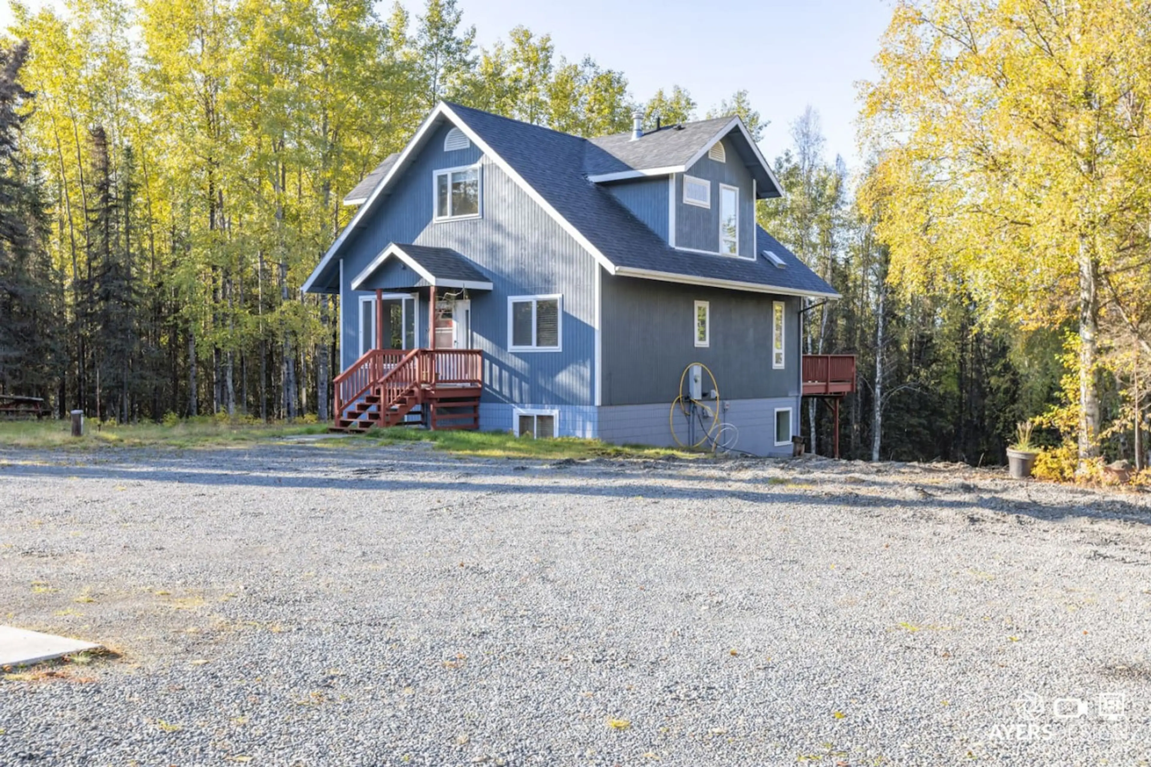 Refined Alaskan interior with linen sofa and view to spruce forest.